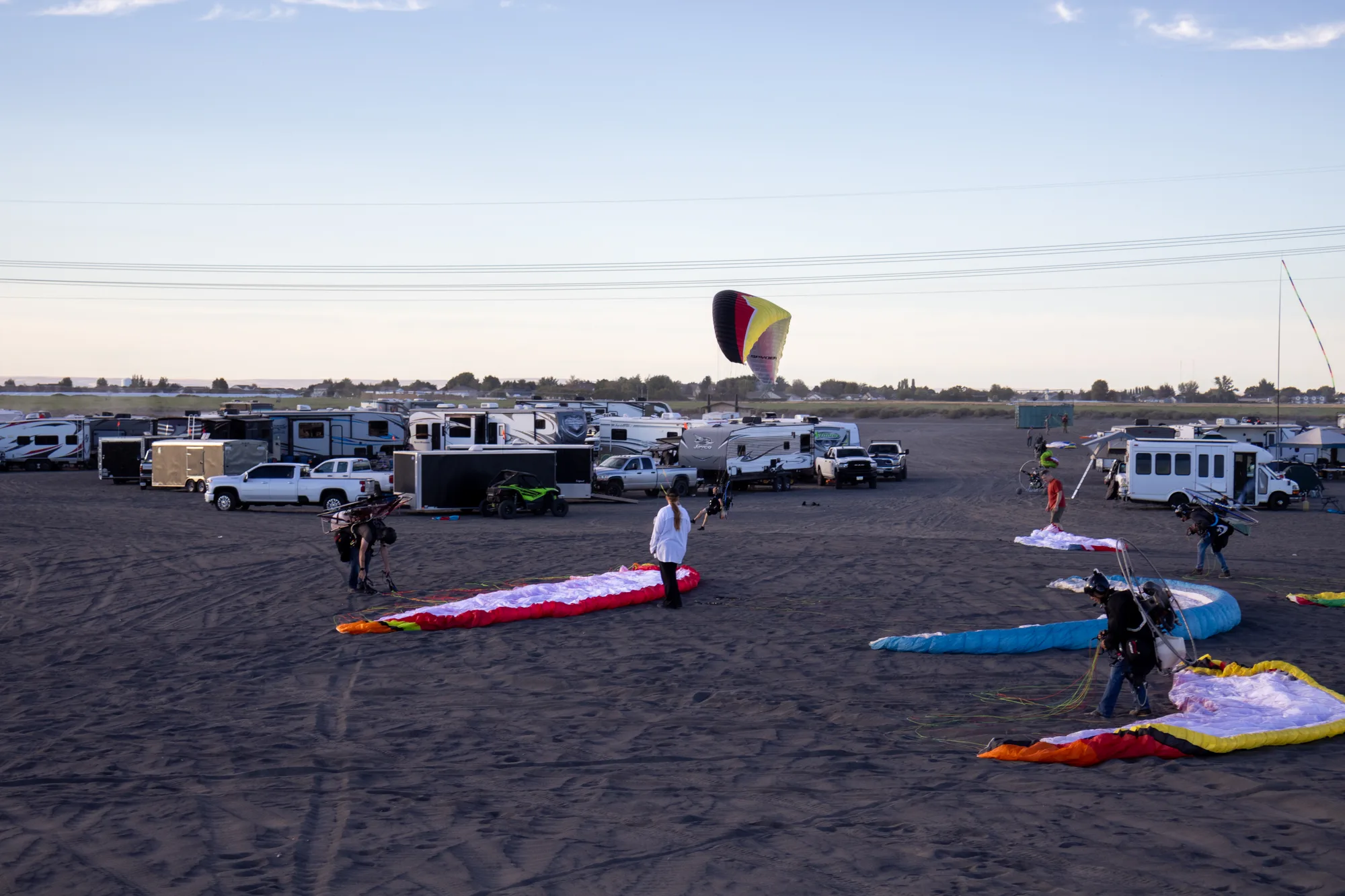 Group of pilots and friends with hot air balloons at dusk